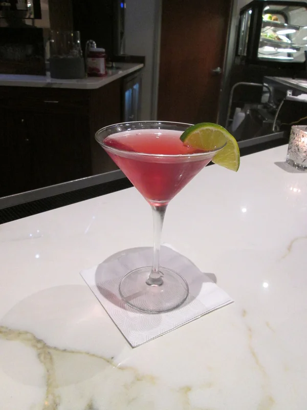 A Cosmopolitan cocktail — vodka, triple sec, cranberry juice, and lime in a martini glass
