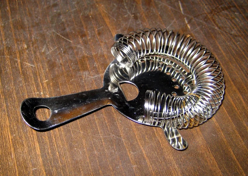 A cocktail strainer — bar equipment used after shaking
