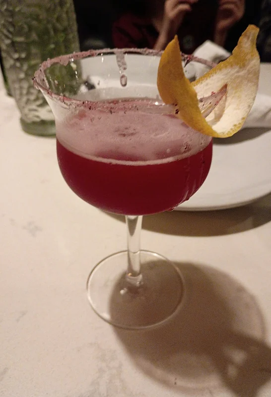 A cocktail finished with aromatic smoke under a glass cloche, illustrating the smoking technique
