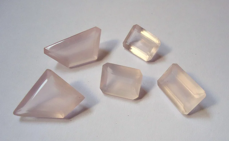 Cut gemstone; rose cut features a flat base with domed triangular facets converging at an apex