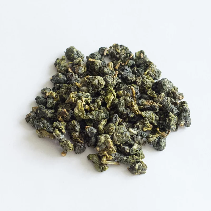 Alishan oolong tightly rolled green pellets with misty mountain backdrop