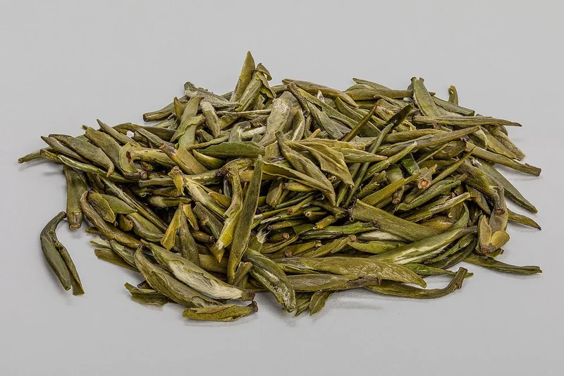 White porcelain cha he with dry oolong tea leaves displayed inside