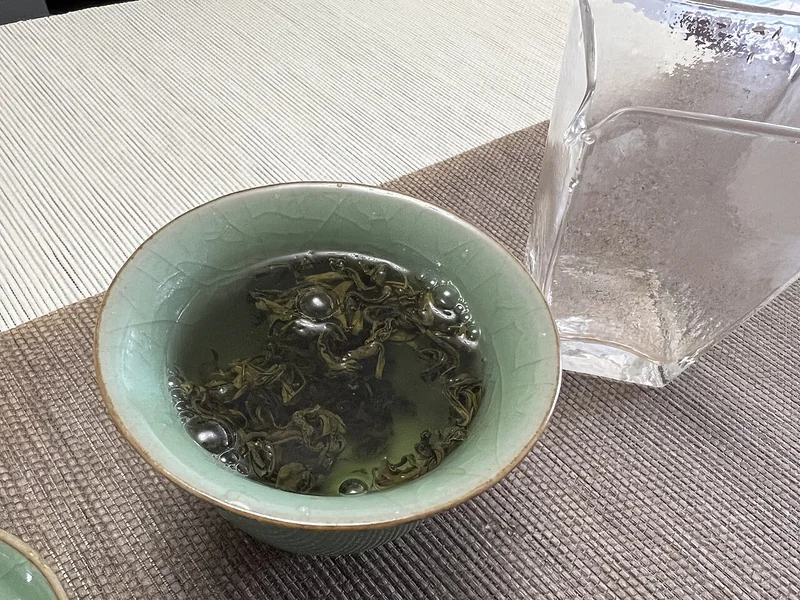 Tea being brewed in a white gaiwan with lid