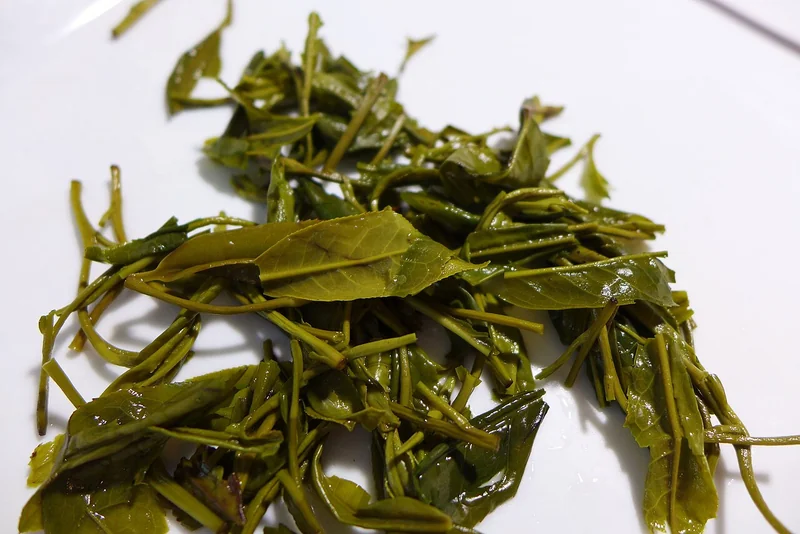 Huangshan Mao Feng green tea dry leaves showing white downy buds