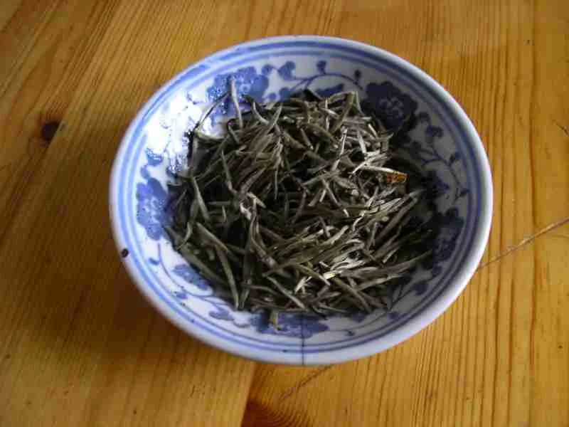 Junshan Yinzhen yellow tea buds in a glass