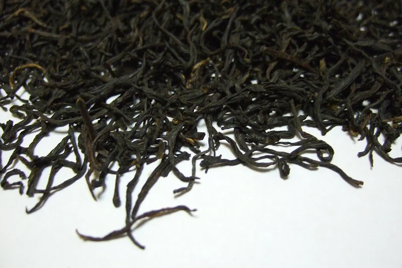 Keemun black tea leaves and a cup of brewed tea