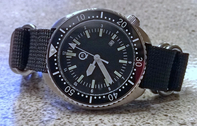 Dive watch with rotating bezel, screw-down crown, and luminous markers on a bracelet