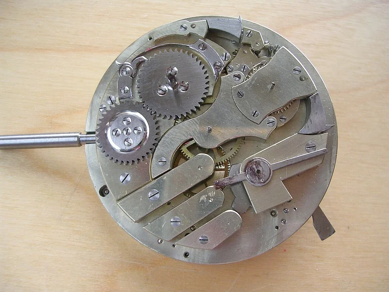 Open pocket watch showing the rack-and-snail minute repeater mechanism with gong hammers