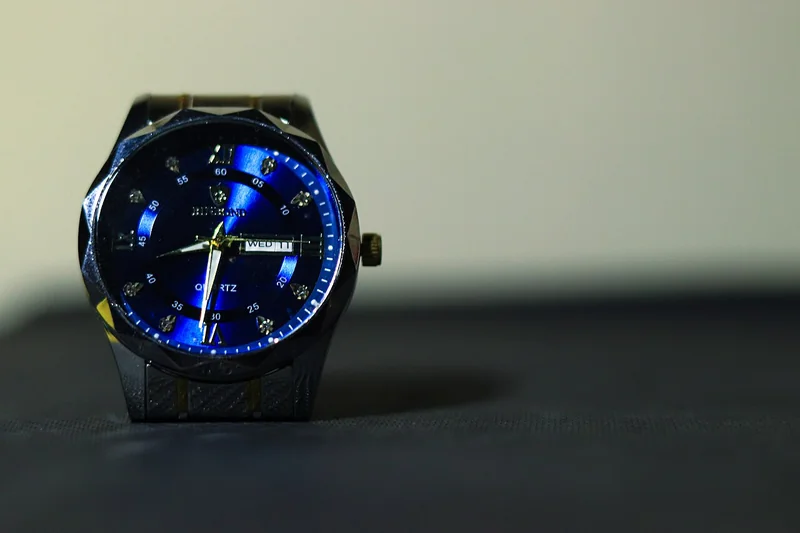 Blue sunburst watch dial showing radial brushing with light reflecting from center outward